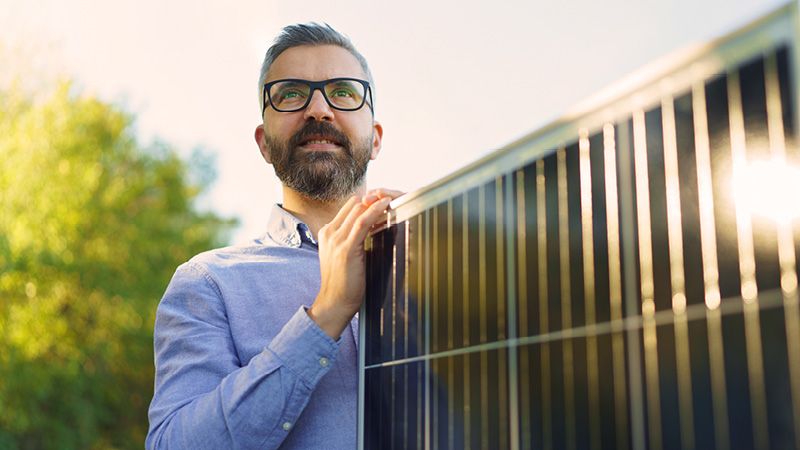 Mann mit Solarmodulen