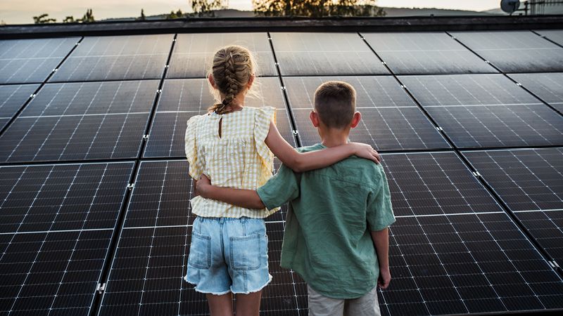 Junge und Mädchen blicken auf Solaranlage